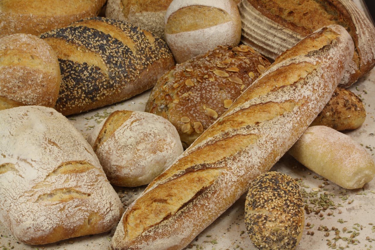 A close-up shot of a variety of artisanal breads including baguettes, sourdough, and seeded loaves.